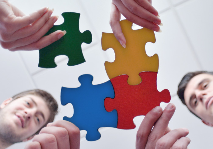 Strategic Enhancement Group / portfolio index image / hands putting puzzle pieces together